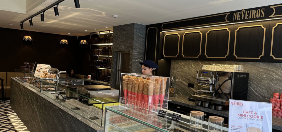 Interior de uma cafetaria/pastelaria Neveiros com balcão, vitrinas de gelados e máquina de café Nespresso
